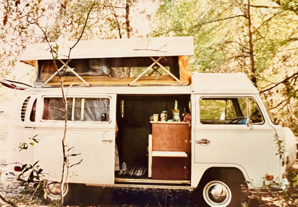 White volkswagen camper in the woods